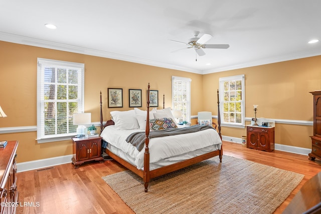 bedroom featuring light wood-style floors, multiple windows, and crown molding