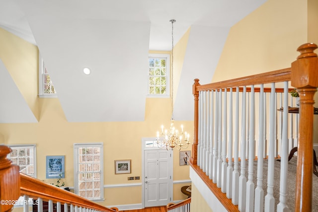 staircase featuring an inviting chandelier and a high ceiling