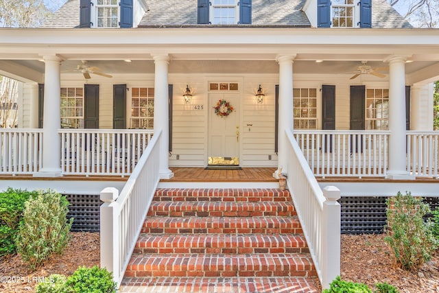 view of exterior entry featuring a ceiling fan, a porch, and a shingled roof