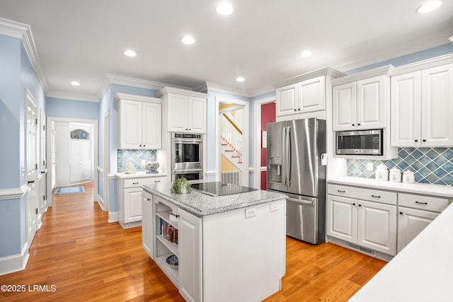 kitchen with white cabinetry, stainless steel appliances, and a center island