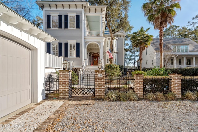 italianate house featuring a fenced front yard and a balcony