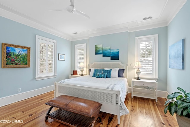 bedroom with baseboards, ornamental molding, visible vents, and light wood-style floors