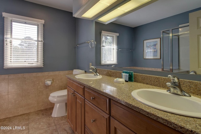 bathroom featuring tile patterned floors, toilet, tile walls, and vanity