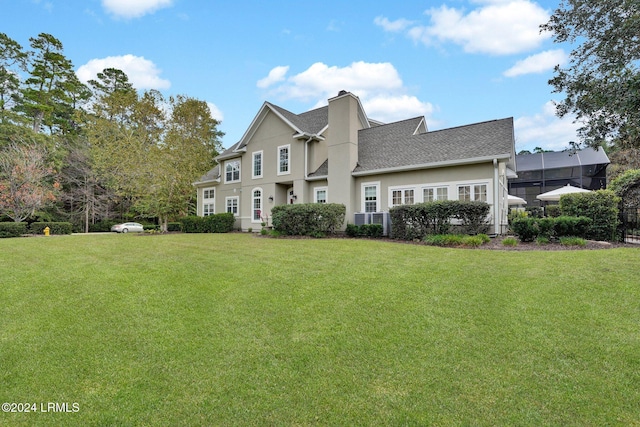 view of front of home featuring a front yard and glass enclosure