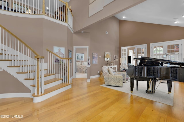 interior space featuring french doors, a towering ceiling, and wood-type flooring