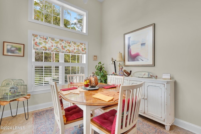 dining room with plenty of natural light, a high ceiling, and light tile patterned flooring