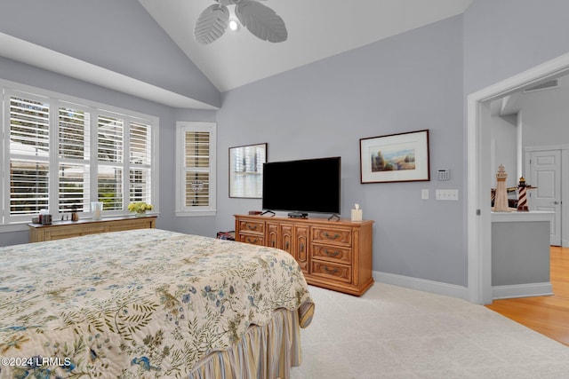 bedroom featuring ceiling fan, high vaulted ceiling, and light colored carpet