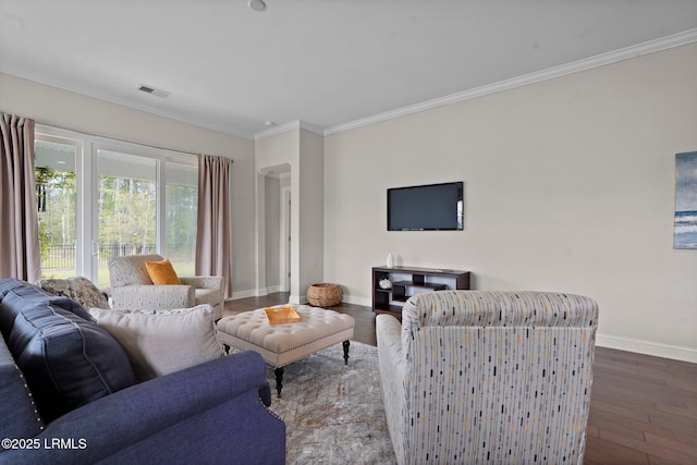 living room featuring baseboards, visible vents, crown molding, and wood finished floors