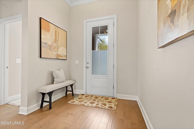 entryway with baseboards, light wood-type flooring, and ornamental molding
