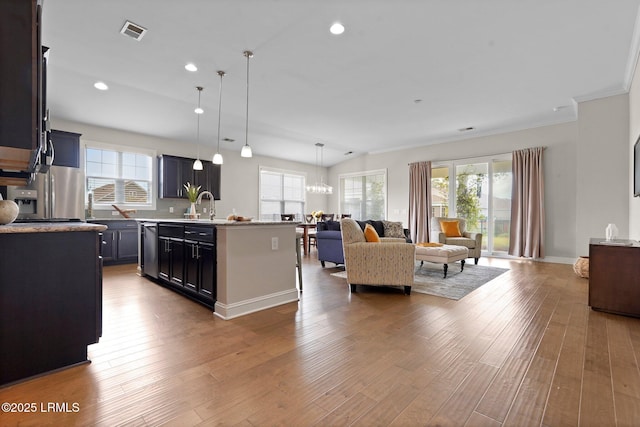 kitchen with open floor plan, visible vents, wood finished floors, and appliances with stainless steel finishes