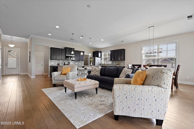 living area with baseboards, light wood finished floors, and recessed lighting