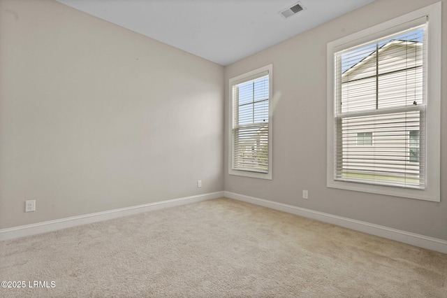 spare room featuring baseboards, visible vents, lofted ceiling, and carpet