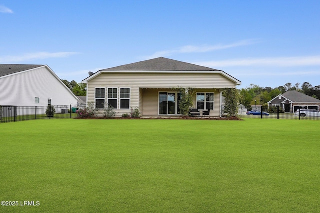 rear view of house with fence and a yard