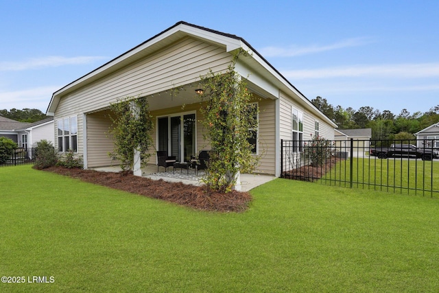 rear view of house with a lawn, fence, and a patio