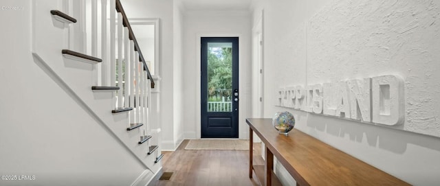 entrance foyer featuring visible vents, a textured wall, dark wood-type flooring, baseboards, and stairs