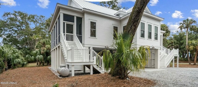 view of front of property featuring driveway, a standing seam roof, and metal roof