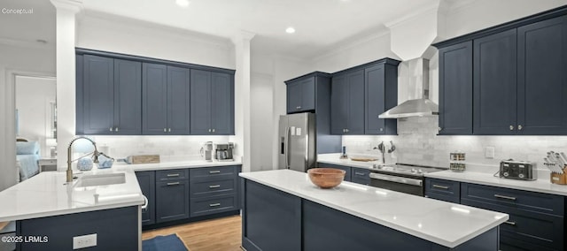 kitchen with appliances with stainless steel finishes, a kitchen island with sink, light countertops, crown molding, and a sink