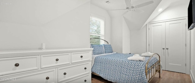 bedroom with visible vents, lofted ceiling, ceiling fan, wood finished floors, and a closet