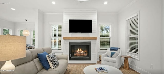 living room with ornamental molding, recessed lighting, a large fireplace, and baseboards