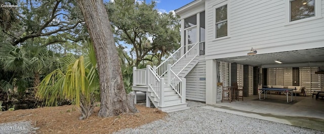 view of side of property with stairs and a patio