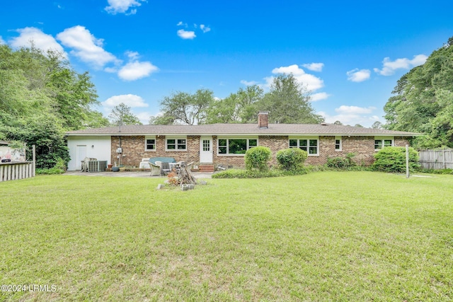 rear view of house with cooling unit, a yard, and a patio area