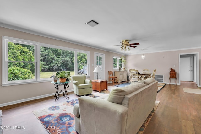 living room with crown molding, a healthy amount of sunlight, ceiling fan, and light hardwood / wood-style floors