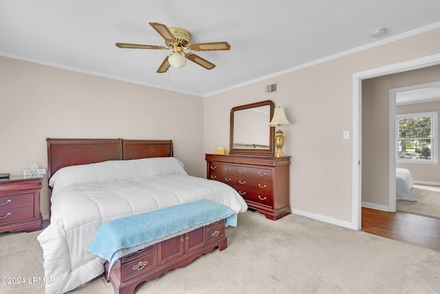 bedroom with light carpet, ornamental molding, and ceiling fan