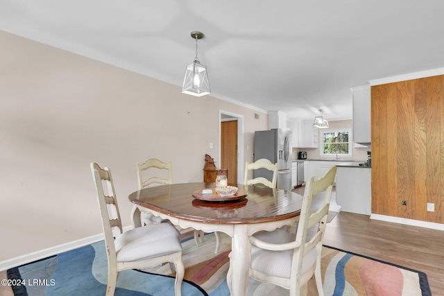 dining room with hardwood / wood-style flooring and ornamental molding