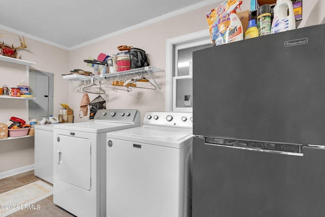 laundry room with washing machine and dryer, light tile patterned floors, and crown molding