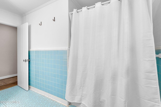 bathroom featuring ornamental molding and tile walls