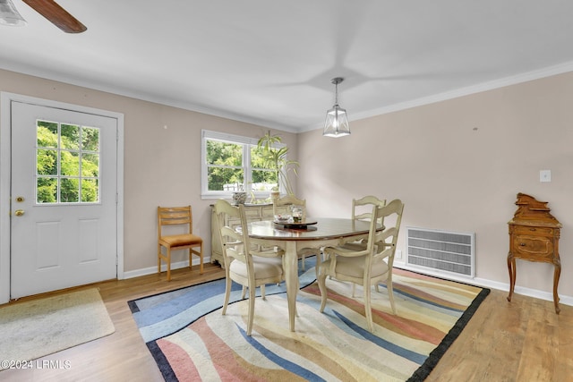 dining space featuring crown molding and light wood-type flooring