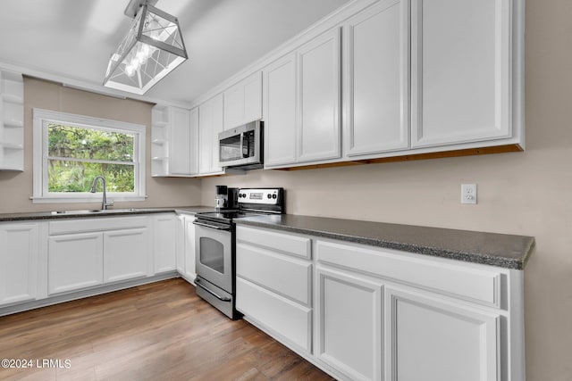 kitchen featuring stainless steel appliances, white cabinetry, sink, and light hardwood / wood-style floors