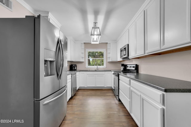 kitchen featuring crown molding, appliances with stainless steel finishes, white cabinets, and dark hardwood / wood-style flooring