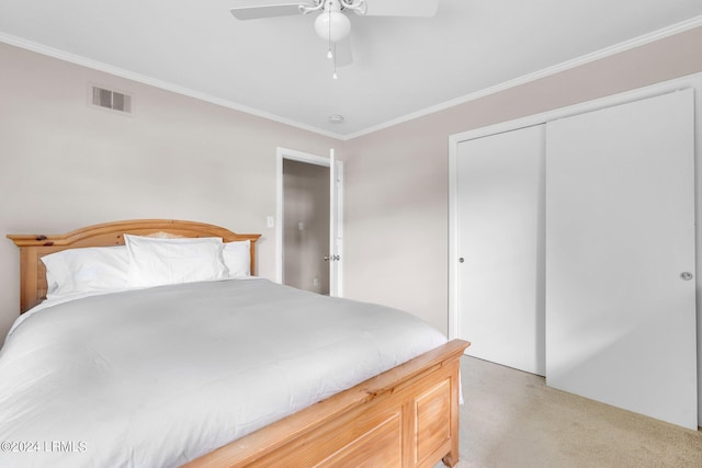 carpeted bedroom featuring ceiling fan, ornamental molding, and a closet