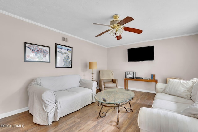 living room with hardwood / wood-style floors, ornamental molding, and ceiling fan