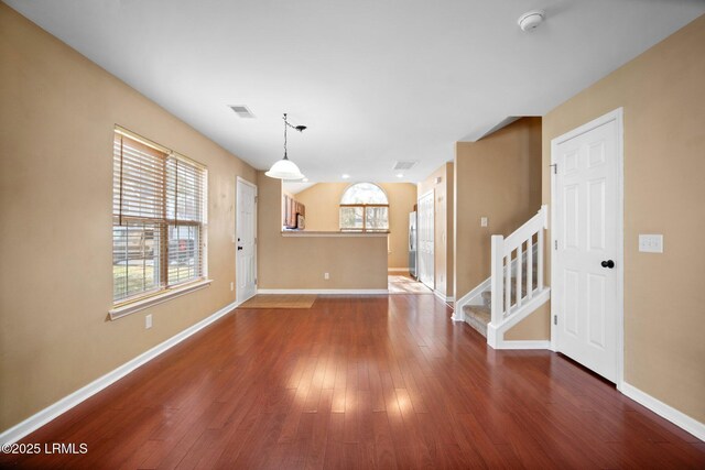 unfurnished room featuring dark wood-style floors, stairway, visible vents, and baseboards