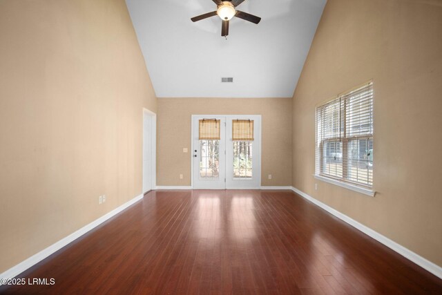 unfurnished room featuring ceiling fan, high vaulted ceiling, wood finished floors, visible vents, and baseboards