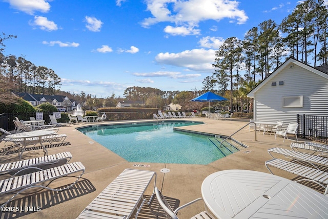 pool with a patio and fence