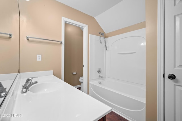 bathroom with toilet, washtub / shower combination, lofted ceiling, and vanity