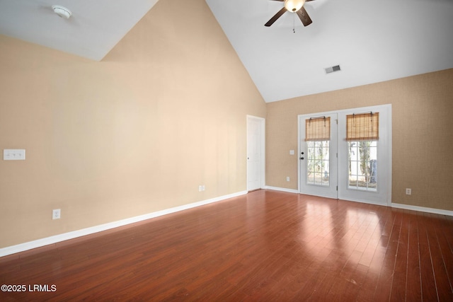 empty room featuring baseboards, visible vents, ceiling fan, wood finished floors, and high vaulted ceiling