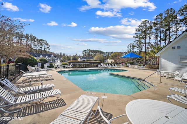 community pool with a patio and fence