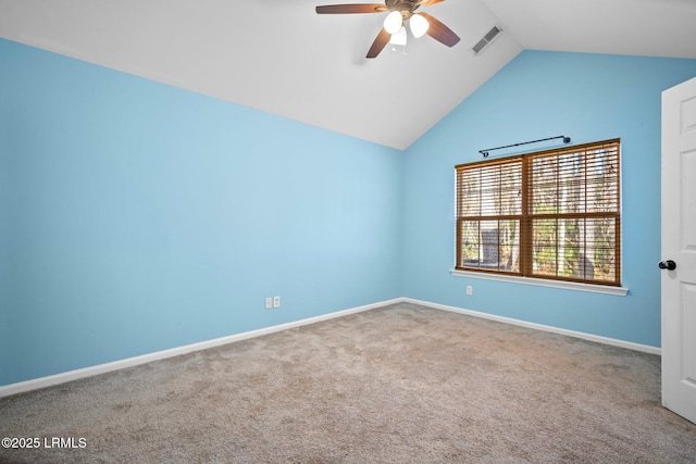 spare room featuring lofted ceiling, visible vents, a ceiling fan, carpet flooring, and baseboards