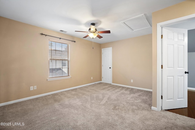 empty room with visible vents, carpet flooring, attic access, and baseboards