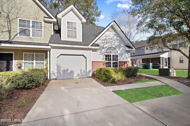 view of front facade with concrete driveway, brick siding, and an attached garage