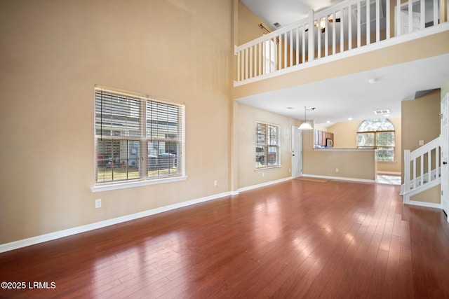 unfurnished living room featuring hardwood / wood-style floors and baseboards