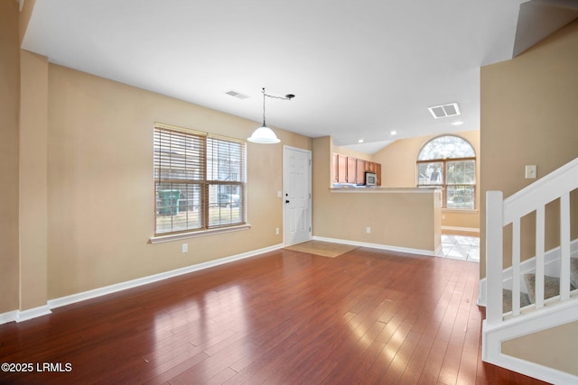 interior space with a wealth of natural light, visible vents, stairway, and wood finished floors