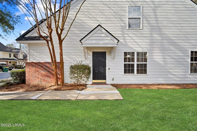 view of front of house featuring brick siding and a front yard