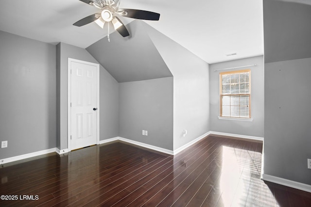 bonus room with lofted ceiling, dark wood-type flooring, a ceiling fan, and baseboards