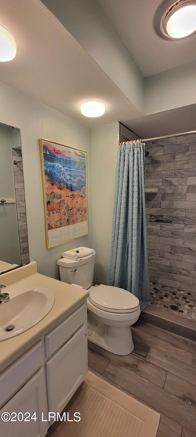 bathroom featuring vanity, hardwood / wood-style floors, toilet, and a shower with shower curtain