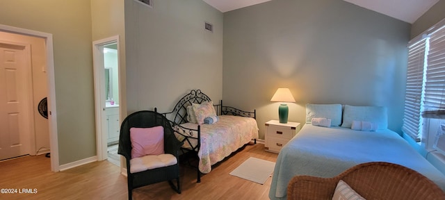bedroom featuring vaulted ceiling and light wood-type flooring